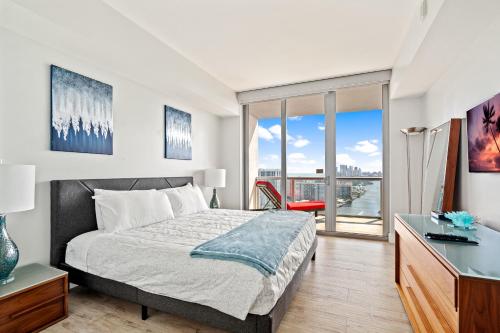 a bedroom with a bed and a desk and a window at Ocean Views - Pool & Gym - Pet Friendly - Close to Beach in Hallandale Beach