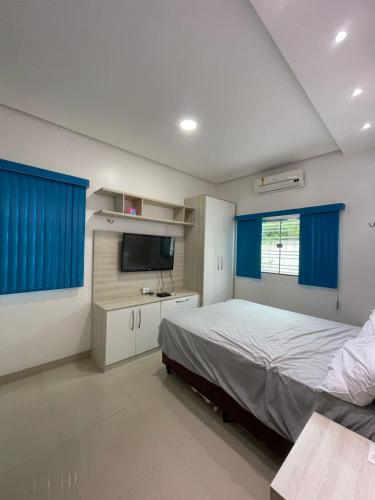 a bedroom with a bed and a flat screen tv at Casa Sales - Alter do Chão in Santarém