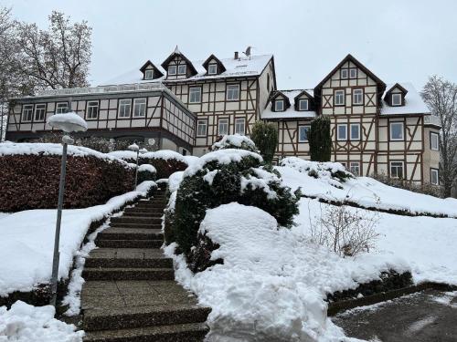 een huis bedekt met sneeuw met trappen voor de deur bij Ferienwohnung in Bad Sachsa mit Grill, Terrasse und Garten in Bad Sachsa