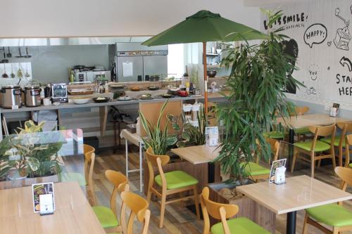 un restaurant avec des tables en bois et des chaises vertes dans l'établissement Yorimichi no Yado - Vacation STAY 37453v, à Toki