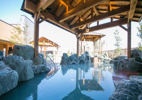 una piscina de agua con rocas en un edificio en Yorimichi no Yado - Vacation STAY 37453v, en Toki