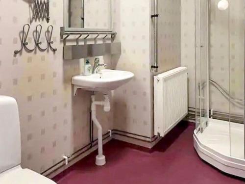 La salle de bains est pourvue d'un lavabo et d'une douche. dans l'établissement Holiday home FREDRIKSBERG III, à Fredriksberg