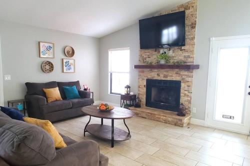 サラソタにあるHidden Gem Home in Sarasota, UTC Mall, Nathan Benderson Park, Siesta Key Beachのソファと暖炉のあるリビングルーム