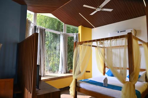 um quarto com uma cama de dossel e uma janela em Olive em Tāla