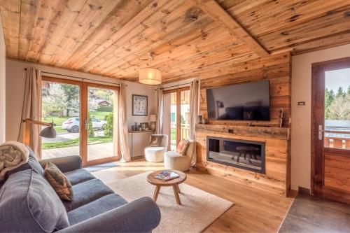 a living room with a couch and a tv at Magnificent chalet with view in Praz-sur-Arly - Welkeys in Praz-sur-Arly