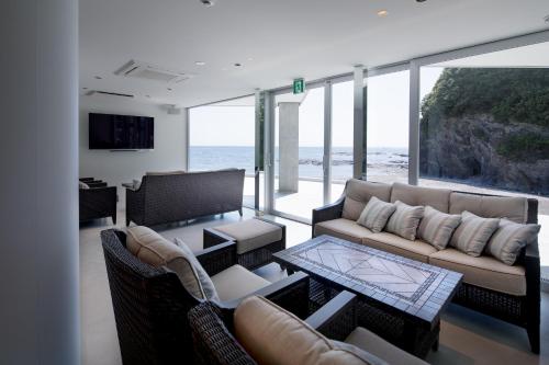 Beach Terrace Kushimoto - Vacation STAY 37415v في Wabuka: غرفة معيشة مع أريكة وطاولة