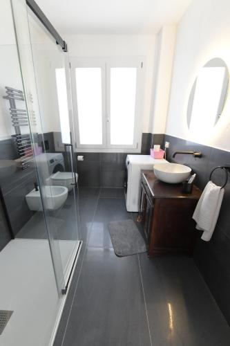 un bagno con due lavandini e una doccia in vetro di Giada a Casalgrande