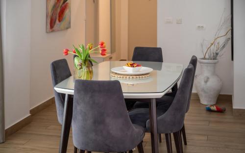a dining room table with chairs and a vase with flowers at Amare Luxury Apartments in Budva
