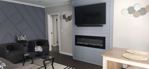 uma sala de estar com lareira e uma televisão na parede em Midtown Haven em Atlanta