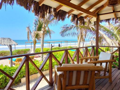 um deque com cadeiras e vista para a praia em El Refugio de Vichayito em Vichayito