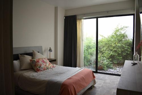 a bedroom with a bed and a large window at Loft Montenegro in Aguascalientes