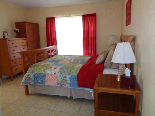 een slaapkamer met een bed, een dressoir en een raam bij A Family Place For You in Port Saint Lucie