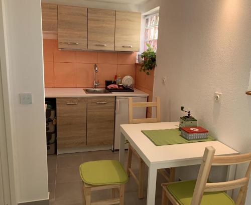 una pequeña cocina con mesa, sillas, mesa, mesa y sillas. en Ferienwohnung für 2 Personen ca 25 qm in Njivice, Kvarner Bucht Krk - b62574, en Njivice