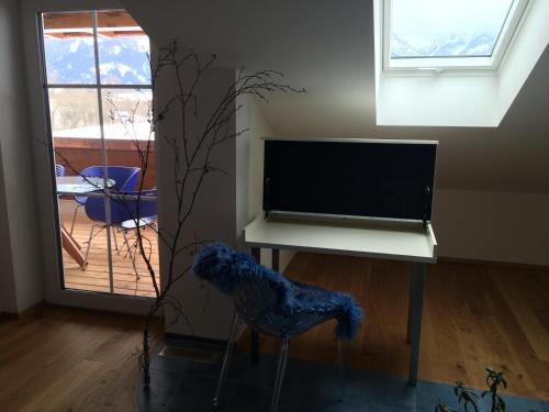 a living room with a tv and a chair and a table at Alpenglück de Luxe Ferienwohnung am Forggensee in Schwangau