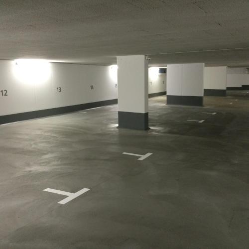 an empty parking lot with white columns in an empty parking garage at Alpenglück de Luxe Ferienwohnung am Forggensee in Schwangau