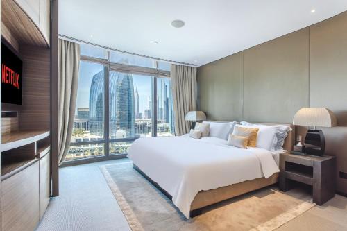 a bedroom with a large bed and a large window at Burj Khalifa, Armani hotel 1 bedroom apartment in Dubai