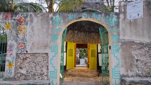 an entrance to a house with a yellow door at Hotel y Museo Aldea Maya Toktli Orígenes - Casa Maya Melipona - Alberca, Wifi Starlink, Tour Museo in Izamal