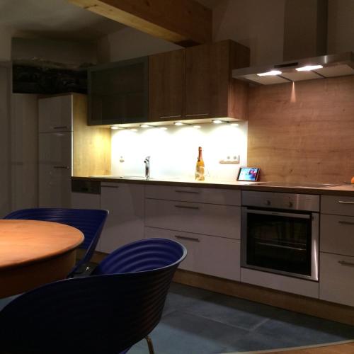 a kitchen with a sink and a table with blue chairs at Alpenglück de Luxe Ferienwohnung am Forggensee in Schwangau