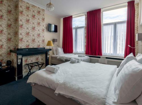 a hotel room with two beds and red curtains at Hotel Rubenshof in Antwerp