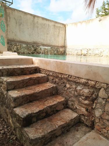 a set of stone steps leading to a swimming pool at Hotel y Museo Aldea Maya Toktli Orígenes - Casa Maya Melipona - Alberca, Wifi Starlink, Tour Museo in Izamal