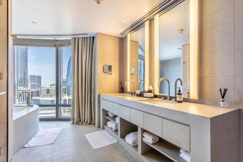 a bathroom with two sinks and a tub and a large window at Burj Khalifa, Armani hotel 1 bedroom apartment in Dubai