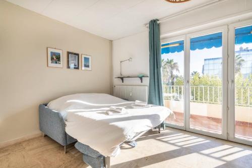 une chambre avec un lit et une grande fenêtre dans l'établissement Studio Crivelli - Welkeys, à Hyères