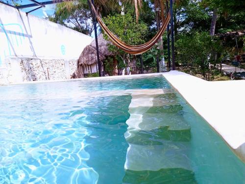 a swimming pool with blue water and a hulavisor at Hotel y Museo Aldea Maya Toktli Orígenes - Suite Casa Maya 3 Culturas - Alberca, Wifi Starlink, Tour Museo in Izamal