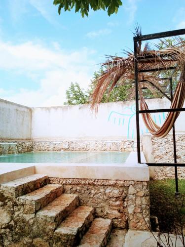 a stone wall with stairs next to the water at Hotel y Museo Aldea Maya Toktli Orígenes - Suite Casa Maya 3 Culturas - Alberca, Wifi Starlink, Tour Museo in Izamal