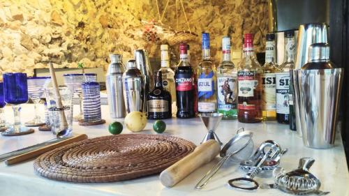 a table topped with bottles of wine and glasses at Hotel y Museo Aldea Maya Toktli Orígenes - Suite La Casa Maya - Alberca, Wifi Starlink, Tour Museo in Izamal