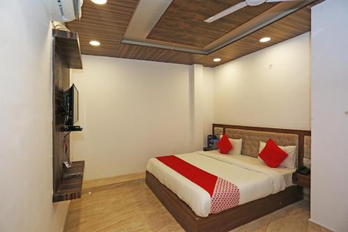 a bedroom with a bed with red pillows at Hotel Rosewood Inn in Rājpur