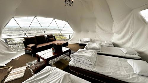 una camera con 2 letti e un divano in una tenda di Shimanto Yamamizuki - Vacation STAY 36955v a Shimanto