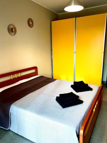 1 dormitorio con 1 cama con 2 almohadas negras en Casa Langhetto, en Grinzane Cavour