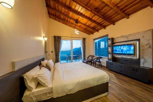 sypialnia z dużym łóżkiem i telewizorem w obiekcie sunset villa w mieście Nainital