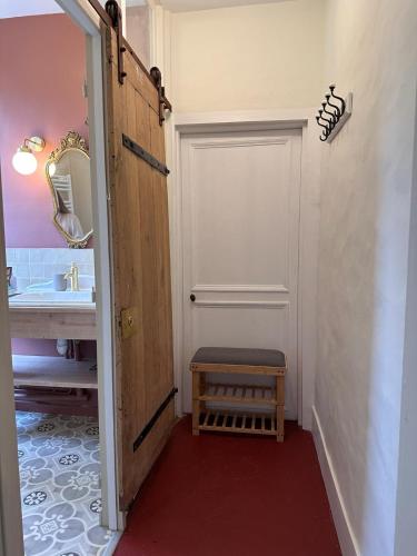 La salle de bains est pourvue d'une porte blanche et d'un lavabo. dans l'établissement La maison de Juliette, appartement de charme, à Épernon