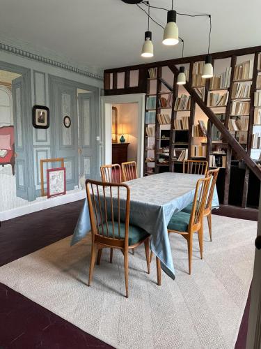 une salle à manger avec une table et des chaises bleues dans l'établissement La maison de Juliette, appartement de charme, à Épernon