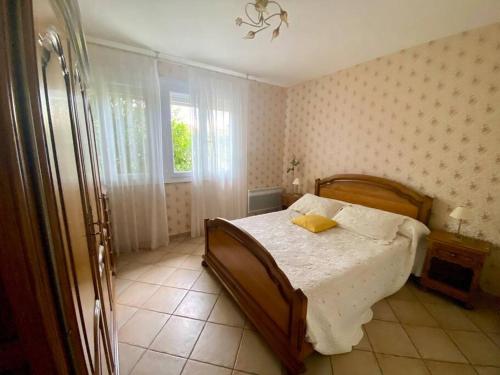 um quarto com uma cama com uma almofada amarela em Palau del Vidre - Villa à 8 min d’Argeles sur Mer em Palau-del-Vidre