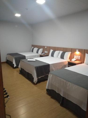 a hotel room with two beds in a room at Hotel American in Ariquemes