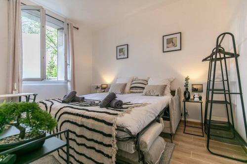 een slaapkamer met een bed met een deken erop bij Appartement 2 personnes Neuf RDC in Gennevilliers