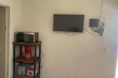 TV en la pared con microondas y cafetera en Casa con alberca privado cómoda, en Tampico