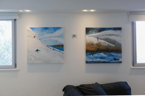 three paintings on a wall in a living room at Luxury Apartment Val di Monte in Malcesine