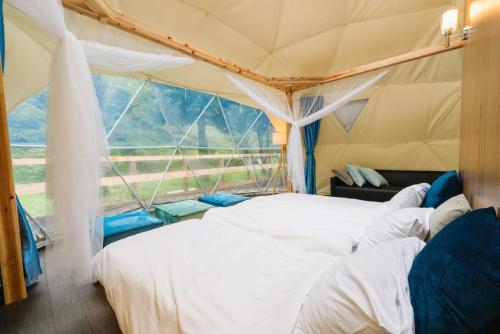 two beds in a tent with a large window at ＳＰＲＩＮＧＳ ＶＩＬＬＡＧＥ - Vacation STAY 67329v in Oyama