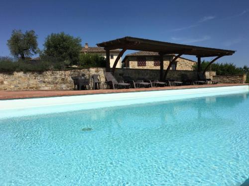 - une piscine avec des chaises et un kiosque dans l'établissement Ferienwohnung für 2 Personen ca 68 qm in Castelnuovo Berardenga, Toskana Chianti, à Castelnuovo Berardenga
