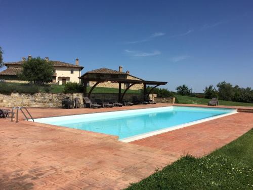 - une piscine avec un kiosque à côté d'une maison dans l'établissement Ferienwohnung für 2 Personen ca 68 qm in Castelnuovo Berardenga, Toskana Chianti, à Castelnuovo Berardenga