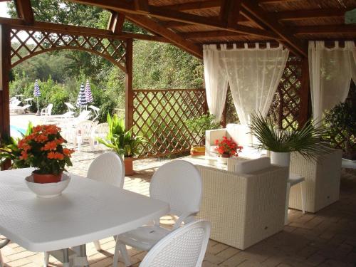 eine Terrasse mit weißen Tischen und Stühlen und einem Zaun in der Unterkunft Studio für 4 Personen  1 Kind ca 80 qm in Pievescola, Toskana Provinz Siena in Casole dʼElsa