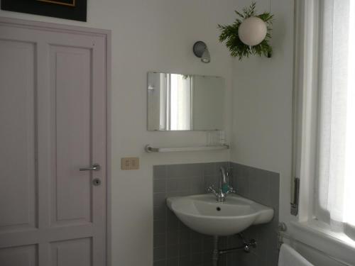 W łazience znajduje się umywalka i lustro. w obiekcie B&B Piccolo Lago w mieście Travedona