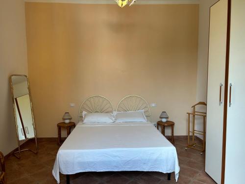 a bedroom with a large white bed with two tables at Carlitos MAISON in Pisa