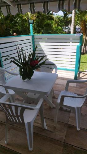 a white table and a chair next to a bench at studio francelu in Sainte-Anne