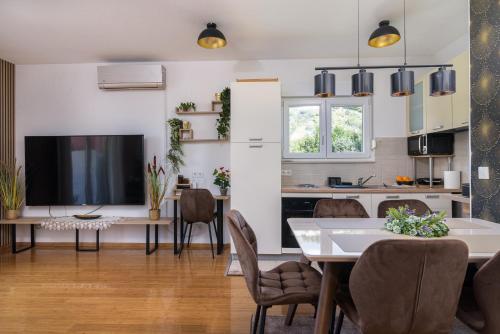 uma cozinha e sala de jantar com uma mesa e uma televisão em GOLDY GREEN em Trogir