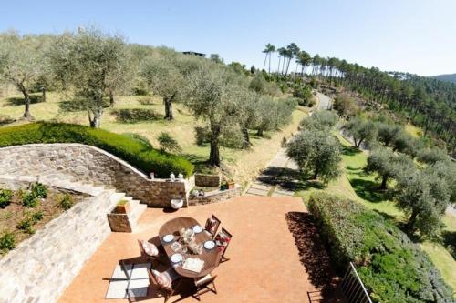 een luchtzicht op een tuin met tafels en stoelen bij Ferienhaus mit Privatpool für 7 Personen ca 200 qm in Capannori, Toskana Provinz Lucca in Capannori