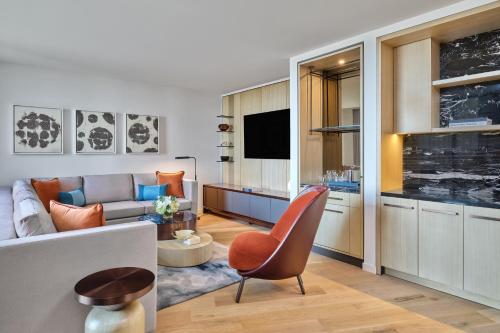 a living room with a couch and a television at The Crescent Hotel, Fort Worth in Fort Worth